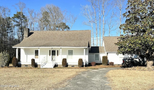 new england style home with crawl space, driveway, a chimney, and a shingled roof