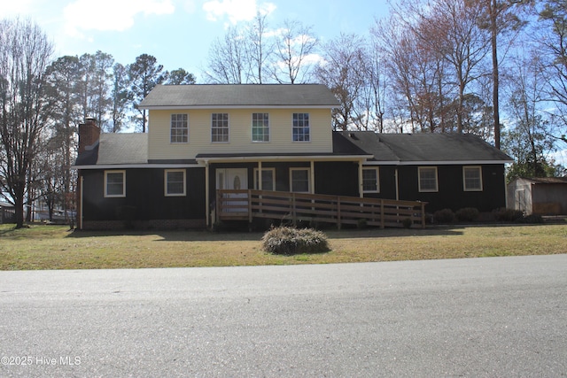 view of front of house with a front lawn, a chimney, and a porch