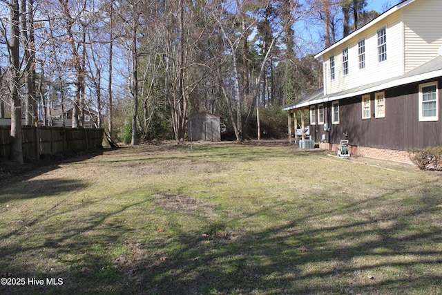 view of yard with a shed, fence, cooling unit, and an outdoor structure