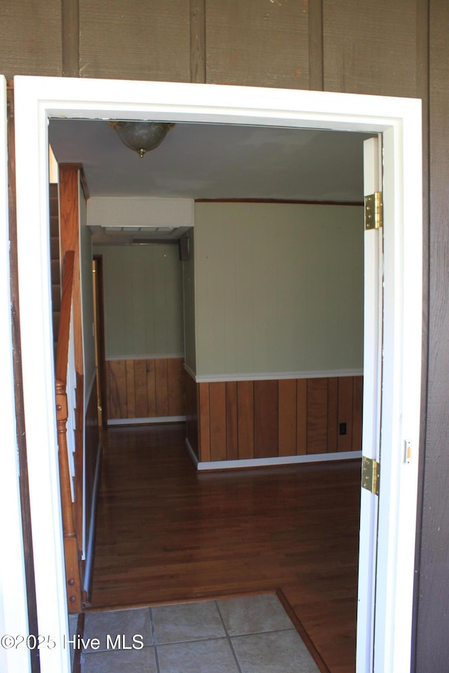 hallway featuring wooden walls and tile patterned floors