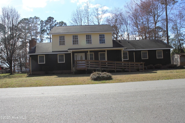 view of front of property with a porch, a chimney, and a front lawn