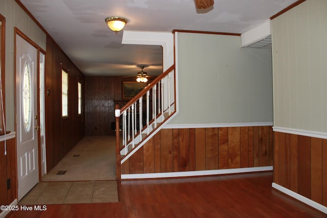 foyer entrance featuring crown molding, stairway, and wood finished floors