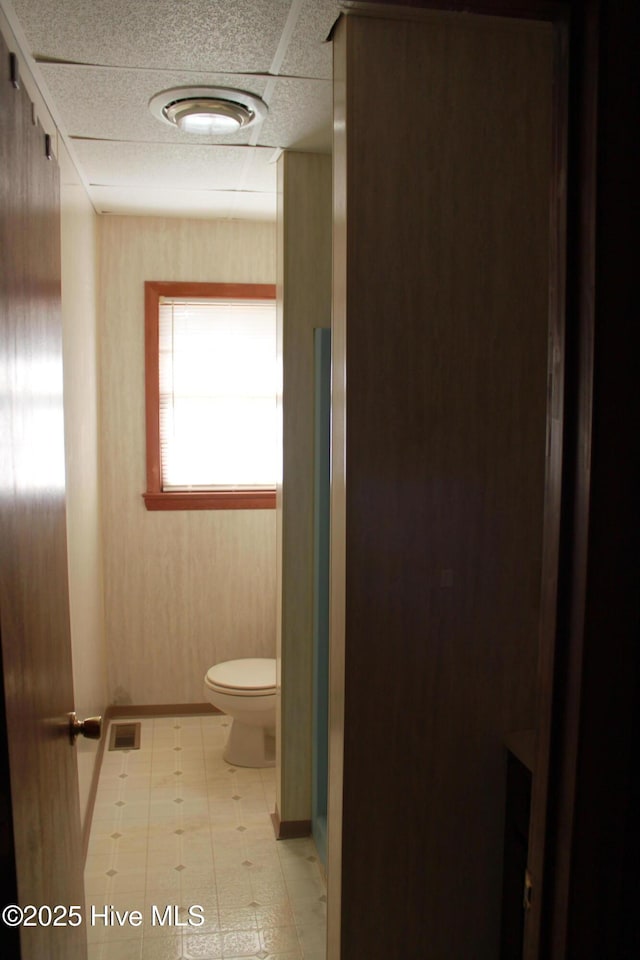 bathroom featuring visible vents, a paneled ceiling, toilet, and tile patterned floors