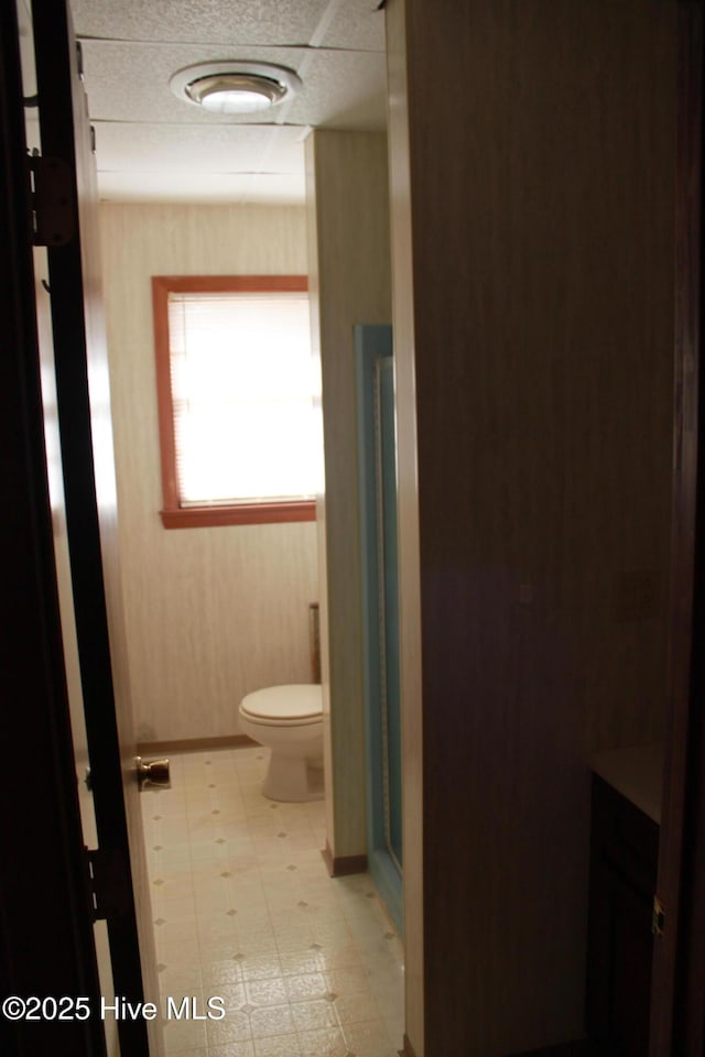 bathroom featuring a stall shower, toilet, and tile patterned floors