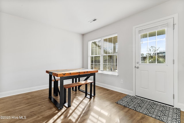 dining room featuring visible vents, baseboards, and wood finished floors