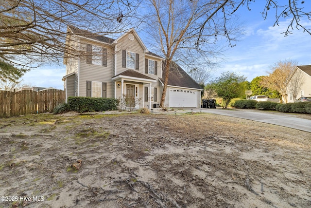 view of front of house with an attached garage, driveway, and fence