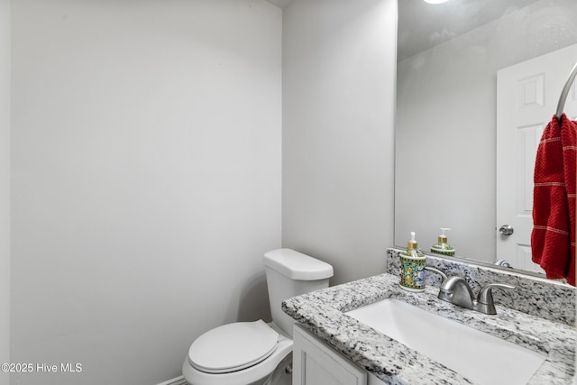 half bathroom with toilet and vanity