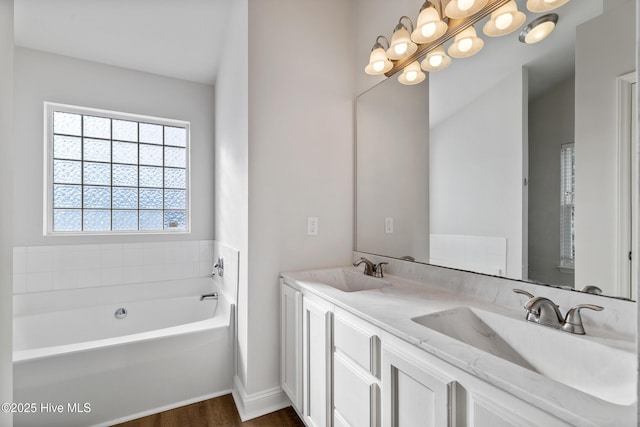 full bathroom featuring a sink, a bath, and double vanity