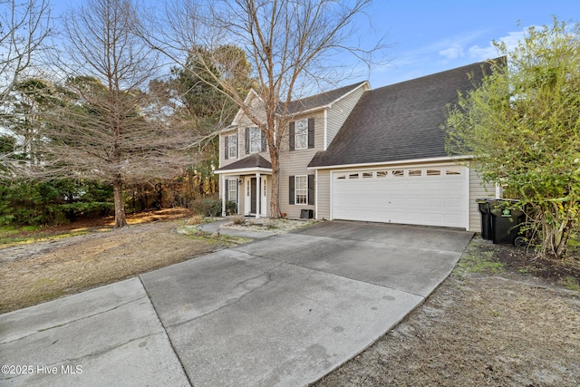 view of front of house featuring driveway, an attached garage, and a shingled roof