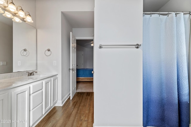 ensuite bathroom with vanity, ensuite bathroom, baseboards, and wood finished floors