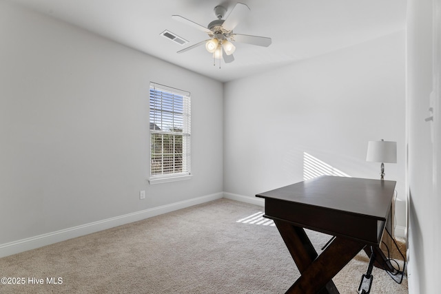 carpeted office featuring visible vents, baseboards, and a ceiling fan