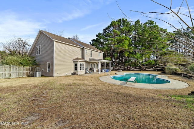 view of swimming pool featuring a lawn, a patio, central AC, fence, and a fenced in pool