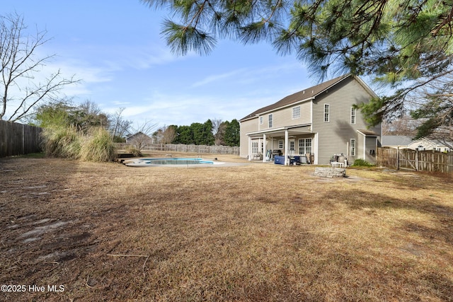 rear view of house with a patio area, a fenced in pool, a lawn, and a fenced backyard