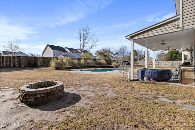 view of yard with ceiling fan, a fenced backyard, a fenced in pool, and a fire pit