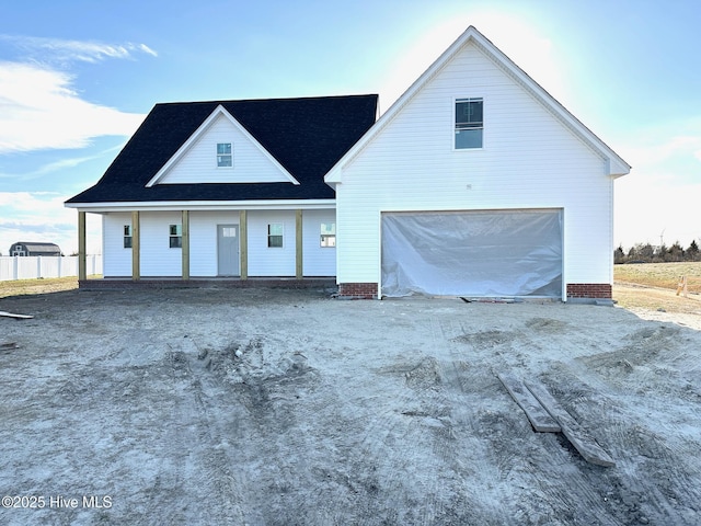 view of front of house with driveway, an attached garage, and fence