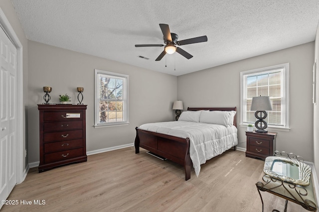 bedroom with visible vents, multiple windows, a closet, and light wood-style flooring