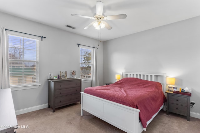 carpeted bedroom with baseboards, visible vents, and ceiling fan