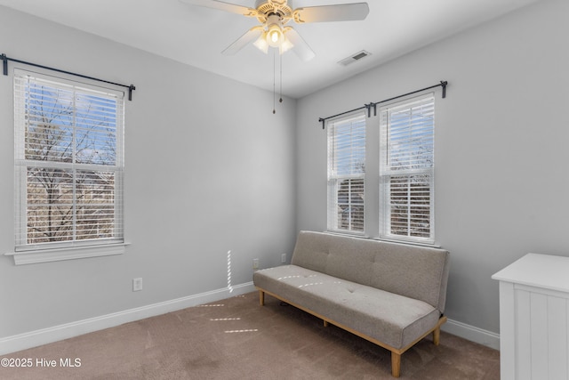 living area featuring ceiling fan, carpet, visible vents, and baseboards