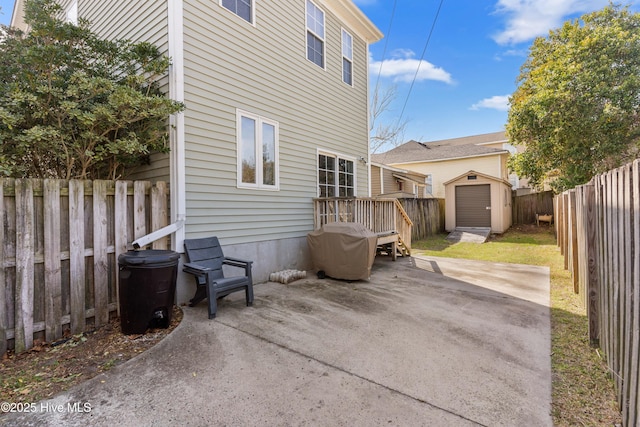 rear view of property featuring a patio area, a fenced backyard, a storage unit, and an outdoor structure