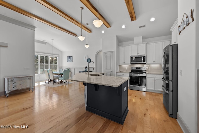 kitchen with light stone countertops, visible vents, lofted ceiling with beams, appliances with stainless steel finishes, and white cabinetry