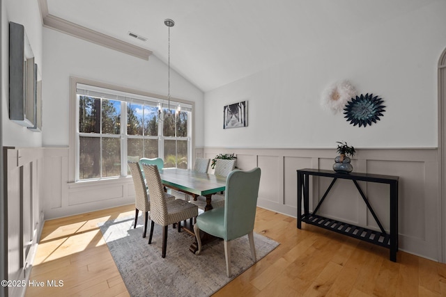 dining space featuring an inviting chandelier, lofted ceiling, visible vents, and light wood-type flooring