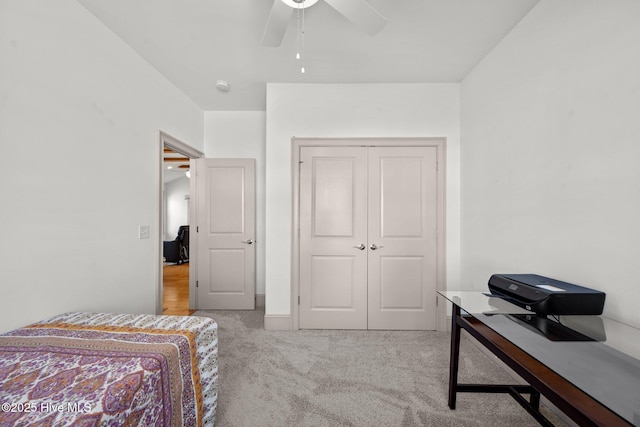 bedroom featuring a ceiling fan, a closet, and light carpet