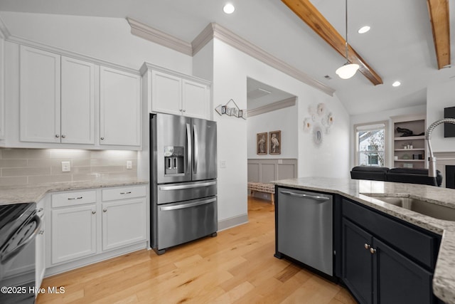 kitchen with light wood-style flooring, a sink, backsplash, stainless steel appliances, and white cabinets