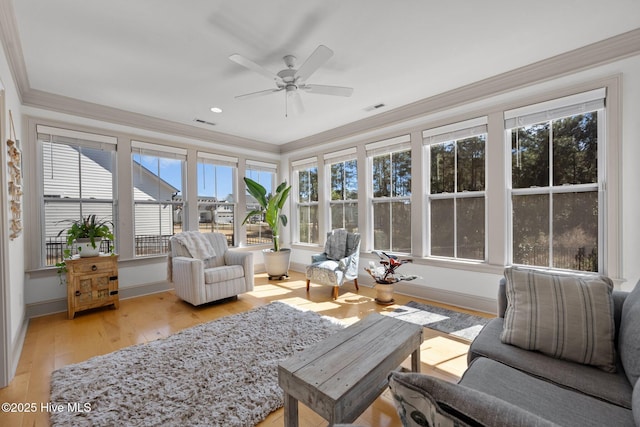 sunroom / solarium featuring a healthy amount of sunlight, visible vents, and ceiling fan