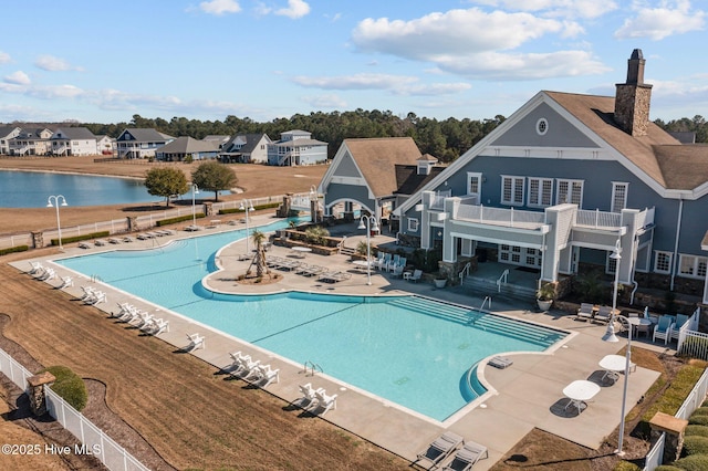 community pool with a residential view, a water view, fence, and a patio area