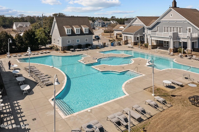 pool featuring a patio area, a residential view, and a hot tub