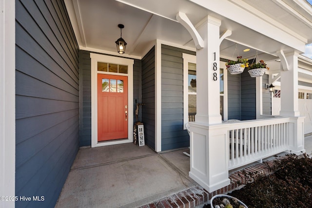 view of exterior entry featuring covered porch and a garage