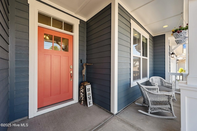 view of exterior entry featuring covered porch