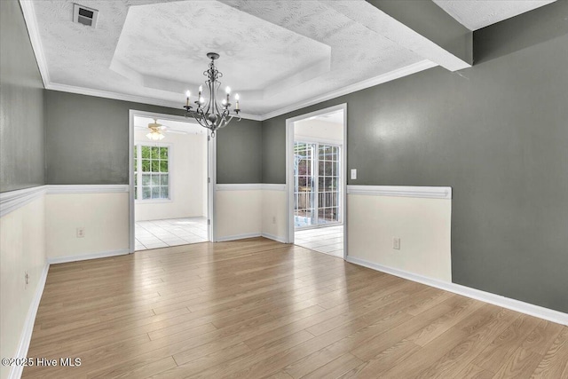148 Mendover Dr, Jacksonville, NC 28546 - empty room with a raised ceiling, a chandelier, wood finished floors, a textured ceiling, and baseboards
