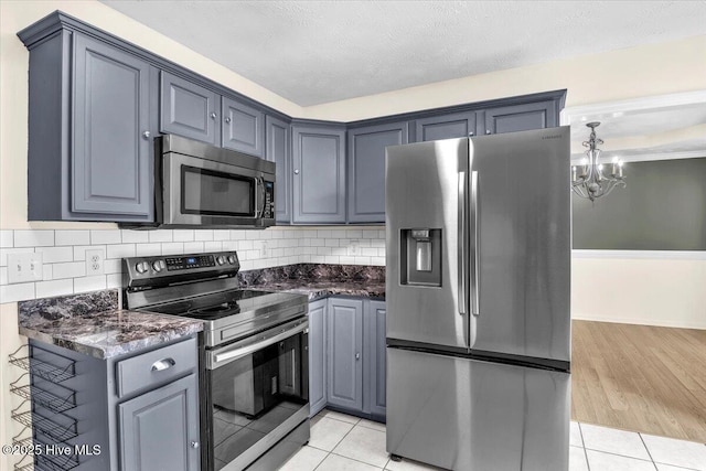148 Mendover Dr, Jacksonville, NC 28546 - kitchen with appliances with stainless steel finishes, a chandelier, light tile patterned floors, and backsplash