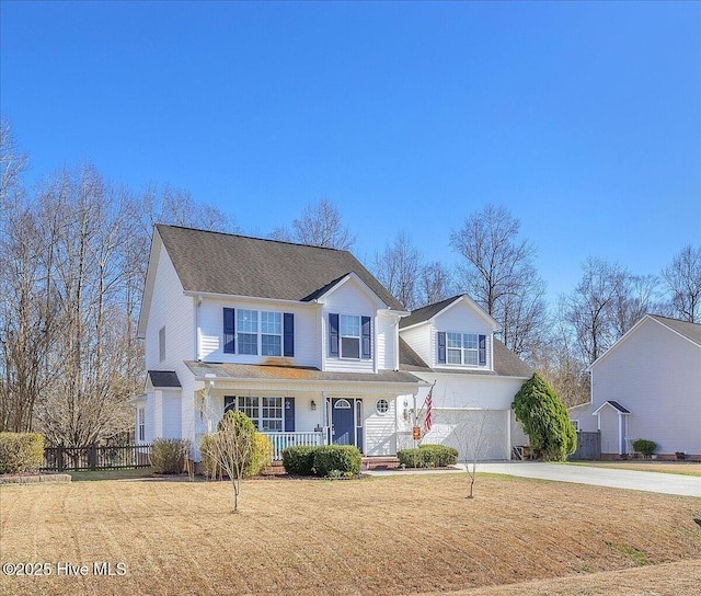 traditional-style home featuring an attached garage, covered porch, fence, concrete driveway, and a front yard