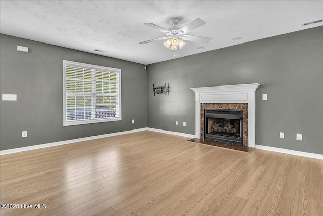148 Mendover Dr, Jacksonville, NC 28546 - unfurnished living room featuring light wood-type flooring, a premium fireplace, a ceiling fan, and baseboards