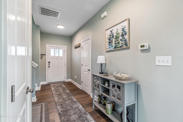 foyer entrance featuring dark wood-style floors, baseboards, and visible vents