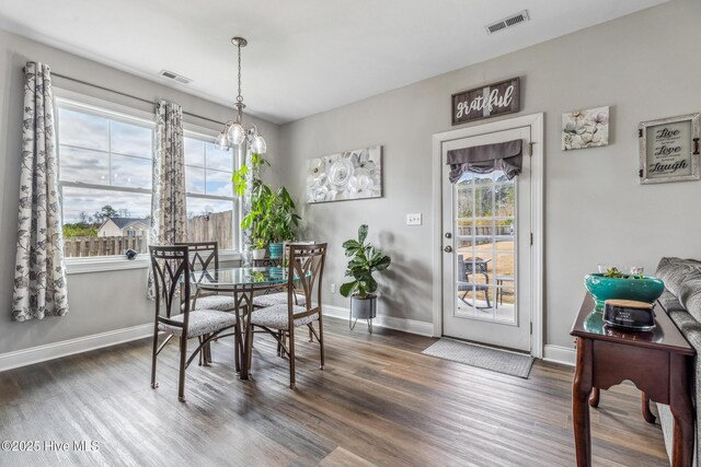 dining space featuring dark wood-style floors, baseboards, and visible vents