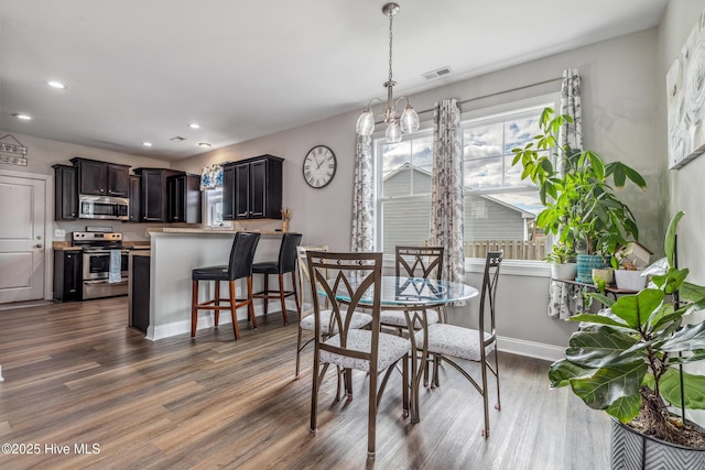 dining space with dark wood finished floors, recessed lighting, visible vents, a chandelier, and baseboards