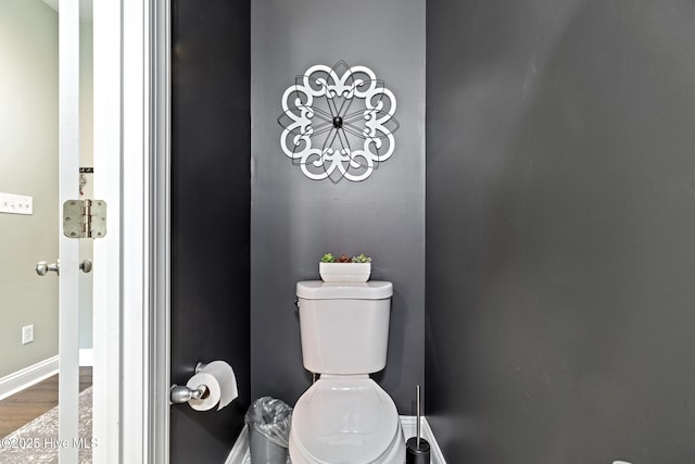 bathroom featuring toilet, baseboards, and wood finished floors