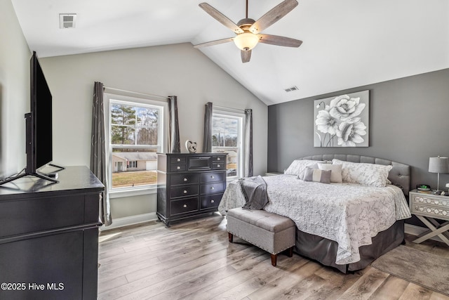 bedroom featuring lofted ceiling, ceiling fan, visible vents, and wood finished floors