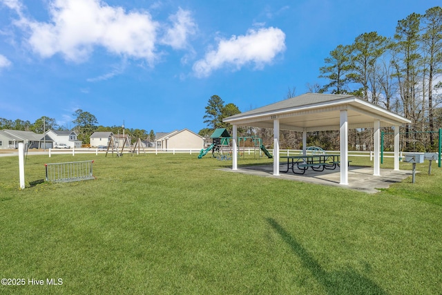 surrounding community with playground community, fence, and a lawn