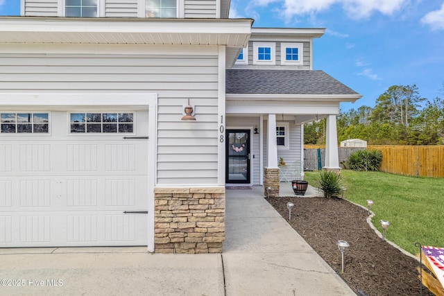 view of front of house with a garage, stone siding, roof with shingles, fence, and a front lawn