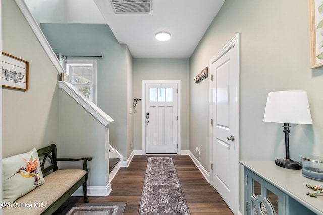 entryway with dark wood-style floors, plenty of natural light, stairs, and visible vents