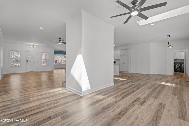 unfurnished living room with light wood-type flooring, plenty of natural light, and crown molding