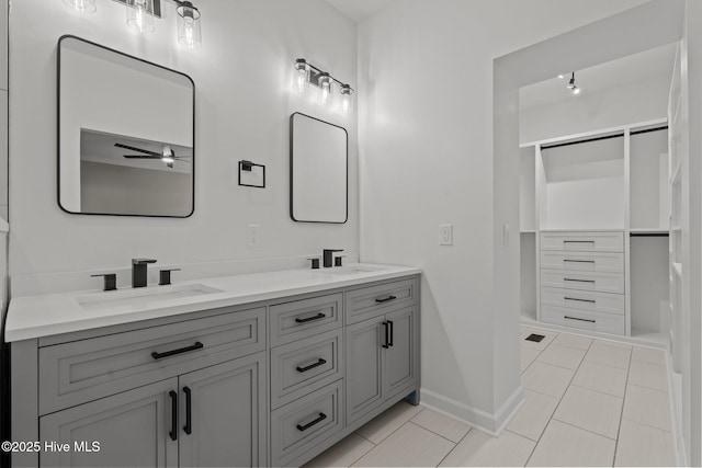 bathroom with ceiling fan, a sink, baseboards, and double vanity