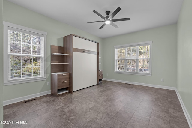 unfurnished bedroom with baseboards, visible vents, and ceiling fan