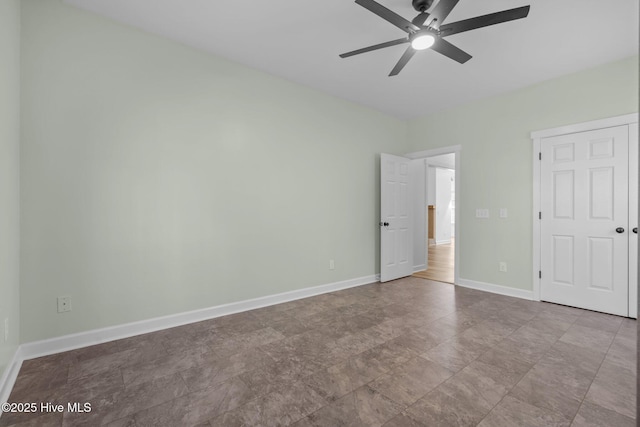 unfurnished bedroom with a ceiling fan and baseboards