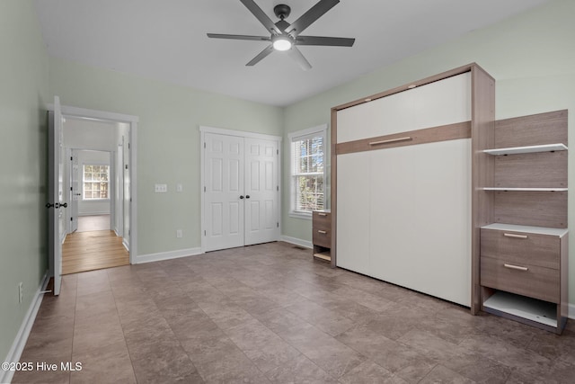 unfurnished bedroom with ceiling fan and baseboards