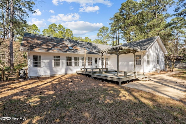 rear view of property featuring a deck, roof with shingles, crawl space, and a pergola